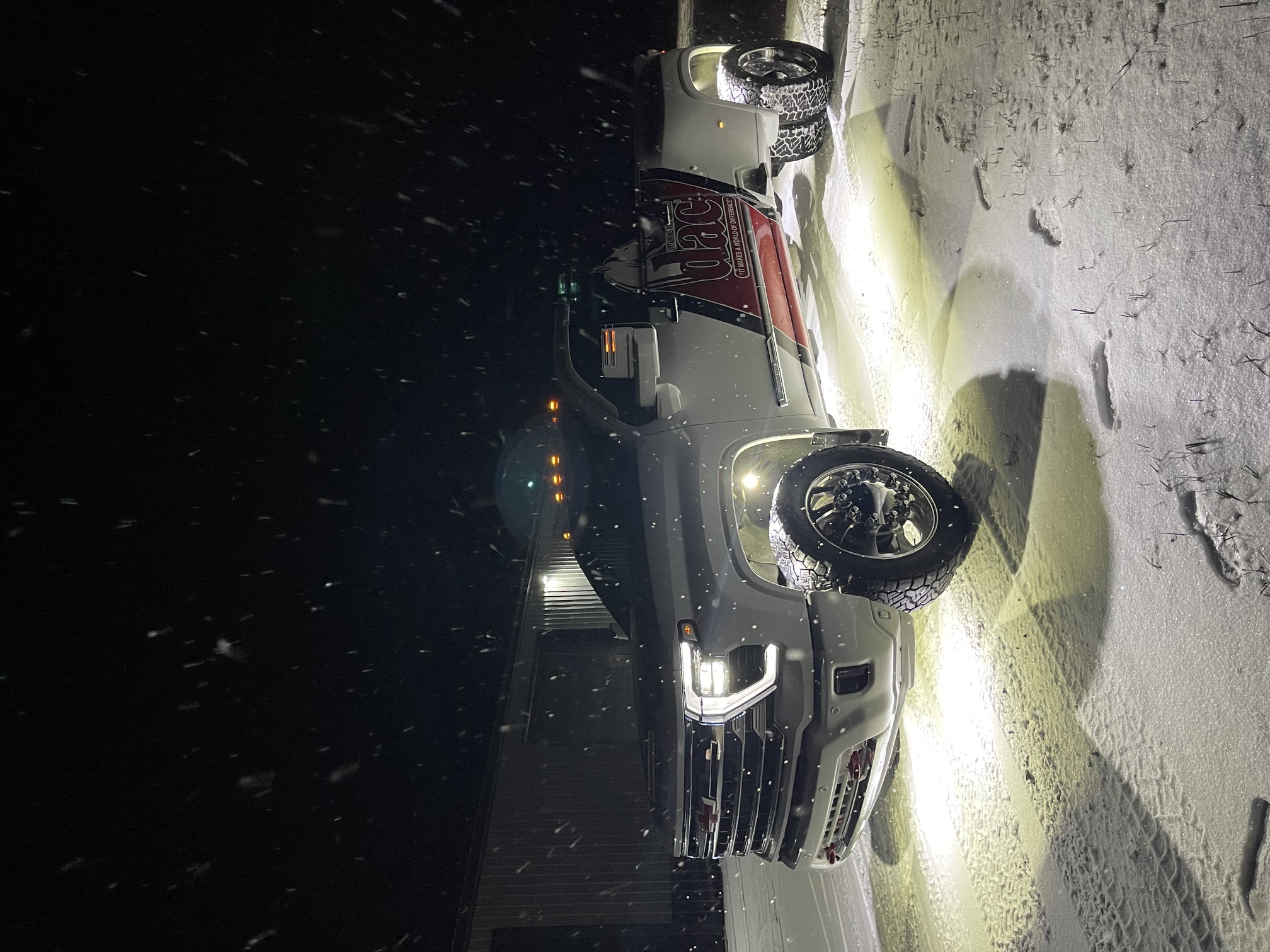 HD Silverado with custom rock lights in snowstorm
