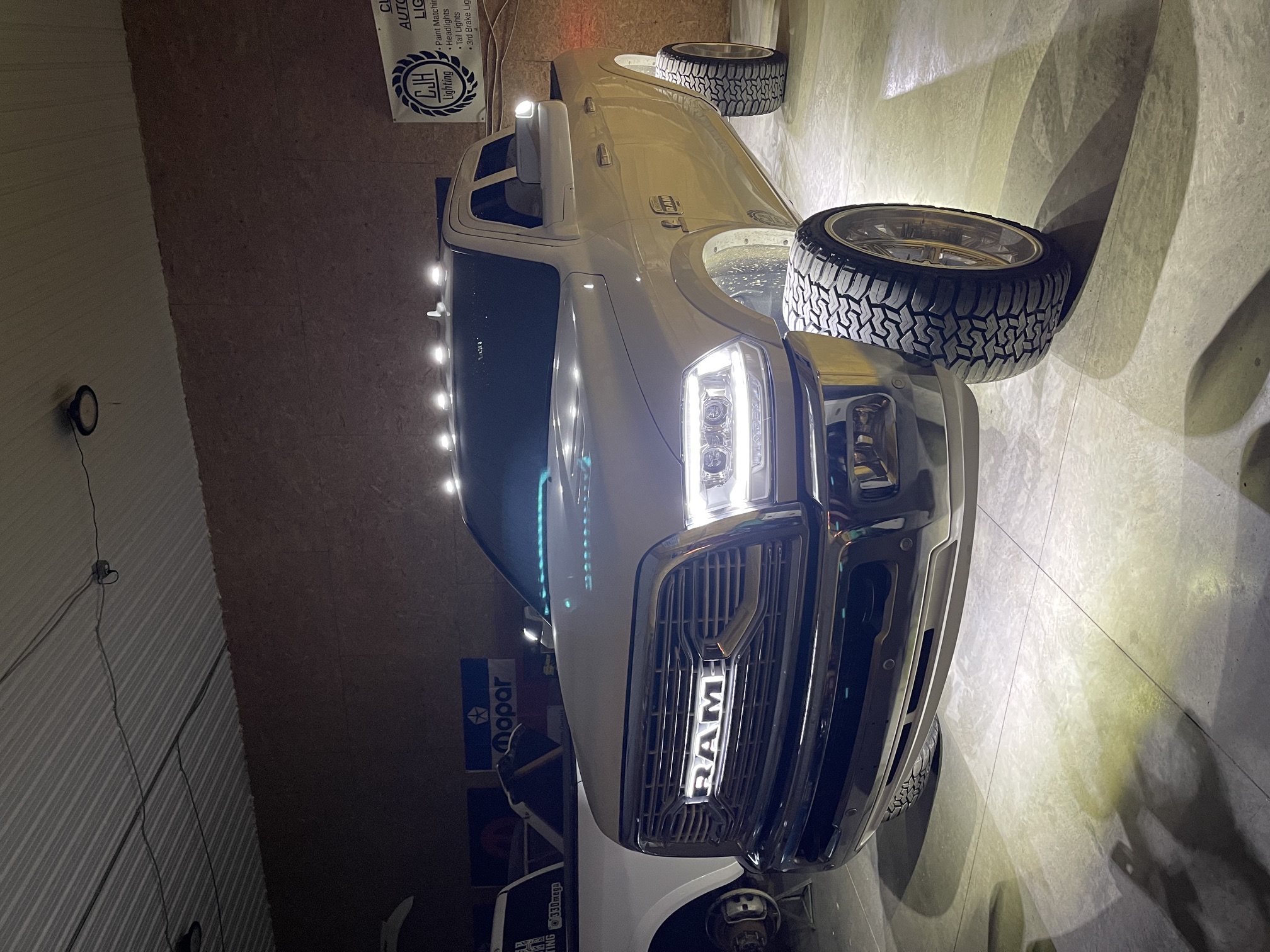 Ram 2500 with custom projector headlights and teal accent lighting